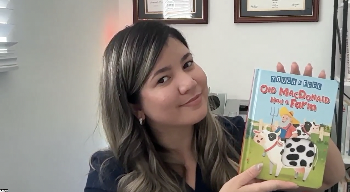 Mary enseña con un libro infantil durante una sesión educativa
